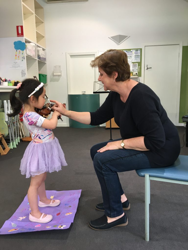 Chantal teaching violin with a young student